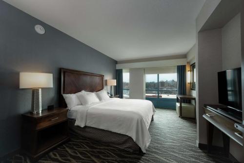 una camera d'albergo con letto e TV di Embassy Suites Saratoga Springs a Saratoga Springs