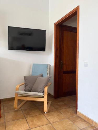 einen Stuhl in einem Zimmer mit einem TV an der Wand in der Unterkunft Bungalows El Palmital - Adults Only in Playa del Ingles