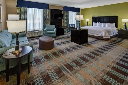 クラークスビルにあるHampton Inn & Suites Clarksvilleのベッドとソファ付きのホテルルーム