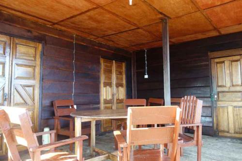 uma sala de jantar com uma mesa de madeira e cadeiras em Robinson's Hut em Bure Town