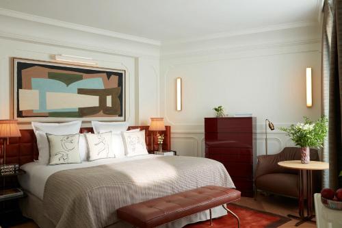 a bedroom with a large bed and a chair at Villa-des-Prés in Paris