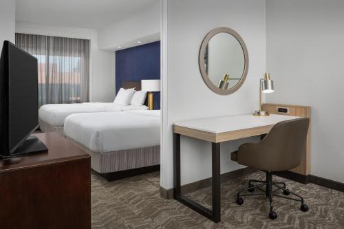 um quarto de hotel com uma secretária, uma cama e um espelho em SpringHill Suites by Marriott Portland Vancouver em Vancouver