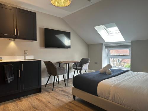 Cet appartement comprend une chambre avec un lit et une cuisine avec une table. dans l'établissement Central Studios, à Cardiff