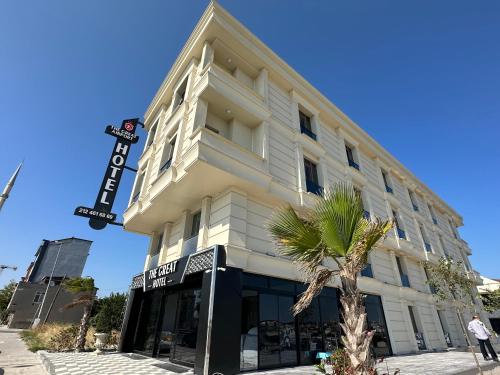 a building with a palm tree in front of it at The Great Airport Hotel in Arnavutköy