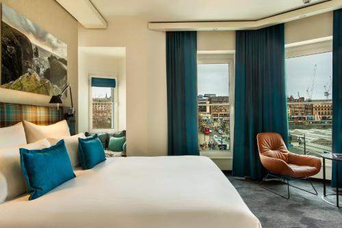 una camera d'albergo con un grande letto e una finestra di Motel One Edinburgh-Royal a Edimburgo