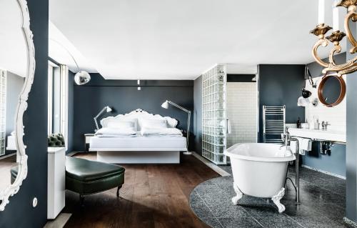 1 dormitorio con cama blanca y bañera en Grand Ferdinand Vienna – Your Hotel In The City Center, en Viena