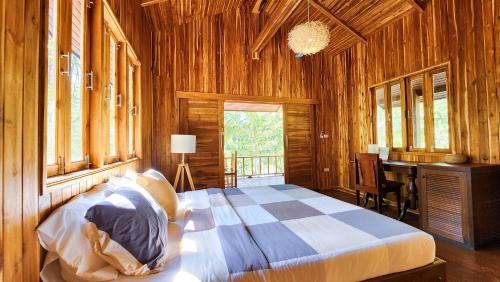 - une chambre avec un lit et un bureau dans l'établissement Baan Bhuwann Forest Chalet, à Ko Pha Ngan