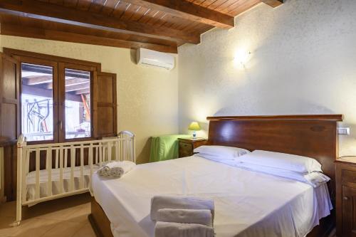 ein Schlafzimmer mit einem Bett mit einem Kinderbett und einem Fenster in der Unterkunft Villa il Panorama di Orrì in Tortolì