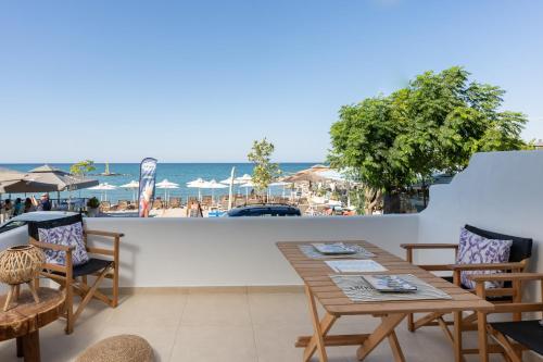 un patio con mesa y sillas y la playa en Galazio Seaside Luxury Rooms & Coffee Shop en Platamonas