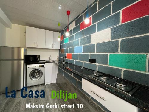 Bedroom La Casa Dilijan N2 في ديليجان: مطبخ بحائط من الطوب وغسالة ملابس