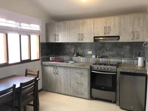 uma cozinha com um fogão e uma mesa em Charming 1-Bed Studio in Huanchaco with balcony em Huanchaco