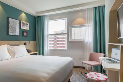 烏特勒支的住宿－Hampton By Hilton Utrecht Centraal Station，酒店客房配有一张床、一张书桌和一台笔记本电脑