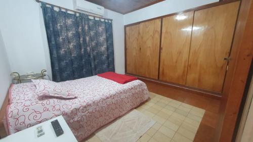 a bedroom with a bed and a wooden cabinet at Tu mejor descanso a una hora de Cataratas Paseos en lancha y aventuras en la selva CONSULTAR in Eldorado