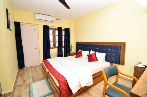 um quarto com uma cama grande e almofadas vermelhas em The Hook BnB, Port Blair em Haddo