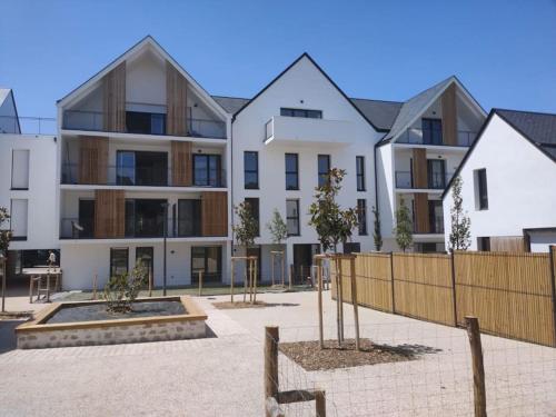 un edificio de apartamentos con una valla delante en Appartement neuf T2 en Saint-Pierre-Quiberon