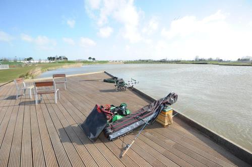 un molo in legno con una barca in acqua di Vakantiehuis Joanitas a Bredene