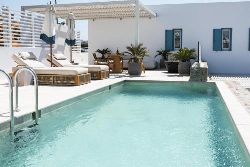 una piscina con sillas y una sombrilla en el patio en Νumi Boutique Hotel en Mykonos ciudad