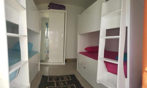 Cette chambre dispose d'étagères blanches et d'un tapis rouge. dans l'établissement Amwaj Ground floor 3BR challet, à El Alamein