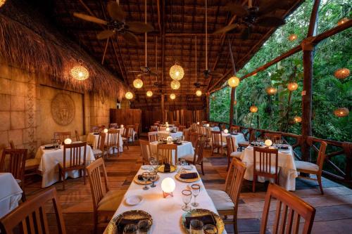 un comedor con mesas, sillas y luces en Viva Azteca by Wyndham, A Trademark All Inclusive Resort, en Playa del Carmen