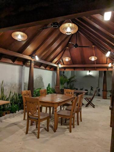 a wooden table and chairs in a pavilion at Araam Inn in Nellaidhoo