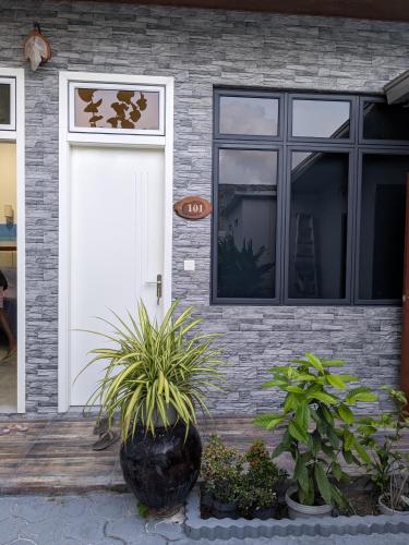 a house with a white door and some plants at Araam Inn in Nellaidhoo