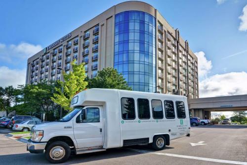 un furgone bianco parcheggiato in un parcheggio di fronte a un edificio. di Embassy Suites by Hilton Minneapolis Airport a Bloomington