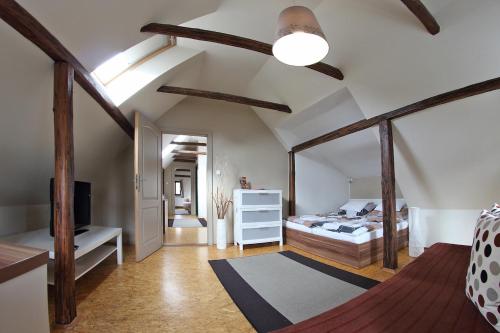 a bedroom with a bed and a ceiling with beams at Apartmány Milenium in Liberec