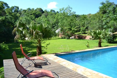 - deux chaises assises à côté de la piscine dans l'établissement Amaraka Lodge, à Leandro N. Alem