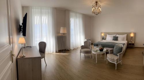 1 dormitorio con 1 cama, mesa y sillas en Hotel Eden Palace au Lac en Montreux