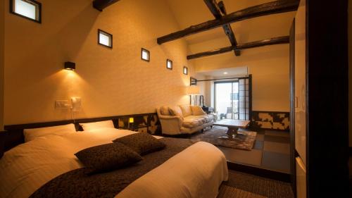 una camera con un letto e una sedia di Beauty&Spa Resort IZU 頬杖の刻 a Izu