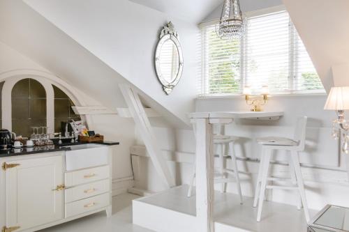 a kitchen with white cabinets and a counter with a stool at Bomans Hotell i Trosa in Trosa