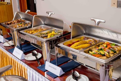 a buffet line with trays of different types of food at HADJENS HOTEL in Mwanza