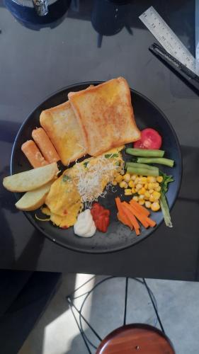 um prato de comida com pão e vegetais numa mesa em Bromo Dormitory & Camp em Bromo