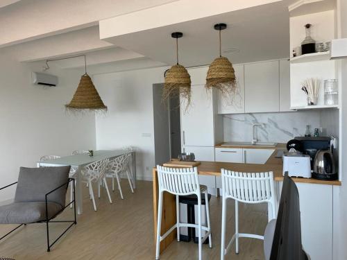 een keuken met witte kasten en een tafel en stoelen bij Canyelles Grandes Vistas by Veuràs el Mar in Roses