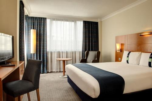 ein Hotelzimmer mit einem Bett und einem TV in der Unterkunft Holiday Inn London Bloomsbury, an IHG Hotel in London