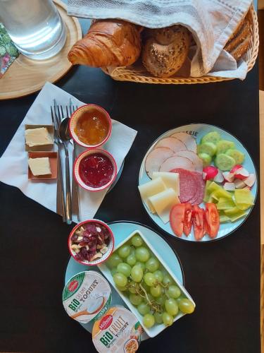 una mesa con dos platos de comida y una cesta de pan en VIGEO lounge b&b coffee, en Bojnice