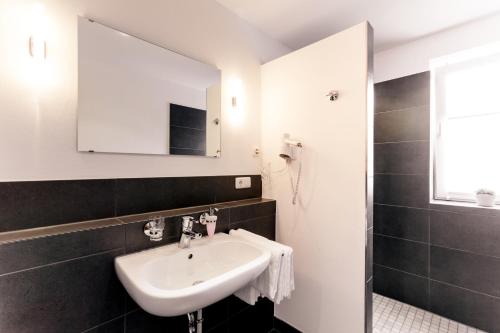 a bathroom with a sink and a mirror at Meyers Hofcafe in Isenbüttel