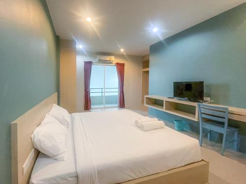 um pequeno quarto com uma cama e uma janela em Hop On Phuket em Ban Bo Han