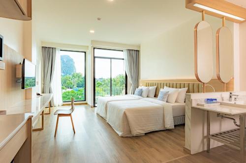 una camera d'albergo con letto e lavandino di Infinity Aonang Krabi - SHA Certified ad Aonang Beach