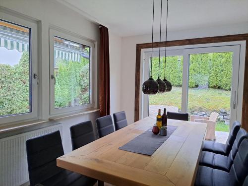 uma sala de jantar com uma mesa de madeira e cadeiras em Chalet Sabrina mit Außenpool im Sommer em Kaprun