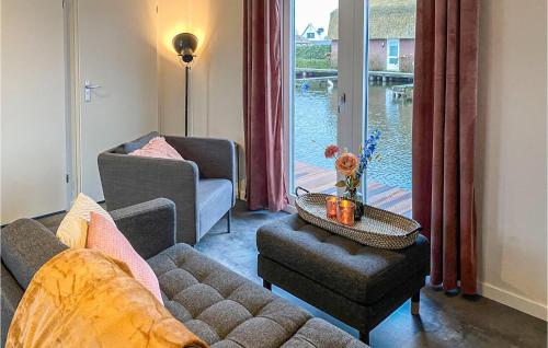 a living room with a couch and a table and a window at Lovely Home In Breukelen With House Sea View in Breukelen