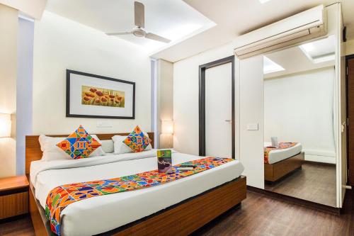 um quarto com uma cama e um espelho em FabHotel Prime Avenue em Indore