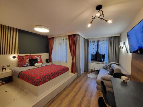 Pinewood ANG luxurious apartment A43, Borovets Gardens في بوروفتس: غرفة نوم بسرير وطاولة واريكة