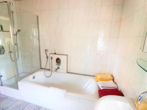 y baño blanco con bañera y ducha. en ABC Ferienwohnungen ABC Wohnung C en Meersburg