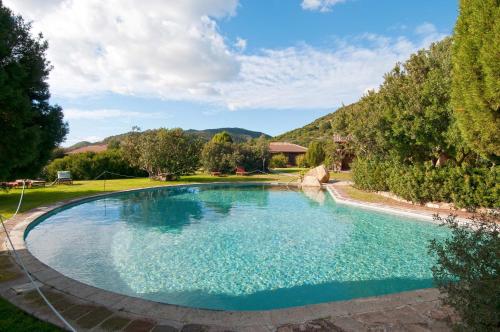 una gran piscina en un patio con árboles en Hotel Spartivento en Chia