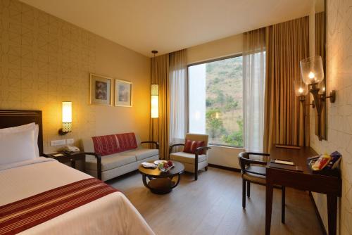 ein Hotelzimmer mit einem Bett und einem Fenster in der Unterkunft Marasa Sarovar Premiere in Tirupati