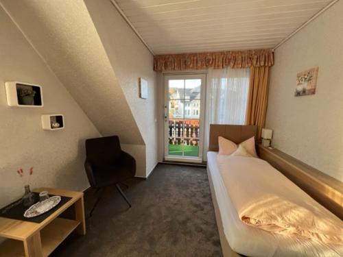 una camera con letto, scrivania e finestra di Sevda's Hotel Garni Weinforth a Willingen