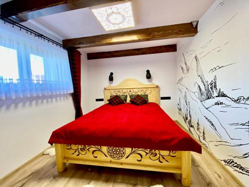 een slaapkamer met een rood bed in een kamer bij Domek Góralski na Ubocy z jacuzzi in Białka Tatrzanska