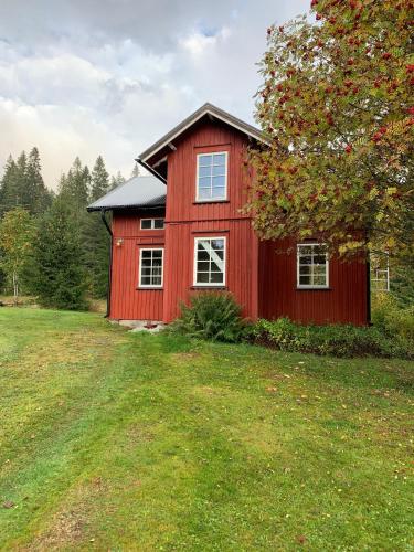 uma casa vermelha no meio de um campo em Rabben em Arjäng