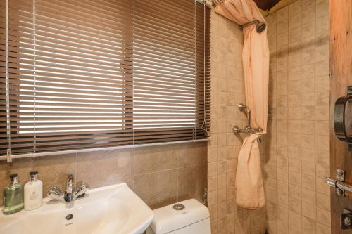 baño con lavabo y aseo y ventana en Shivapuri Heights Cottage en Katmandú